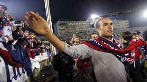 Donovan celebrates with fans after the match. He and teammates led a cheer of "I believe that we can win!"