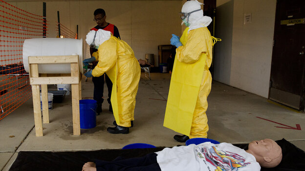 At a CDC training session for clinicians headed to West Africa, a medical worker practices sanitizing hands after drawing blood from a mannequin portraying an Ebola patient.