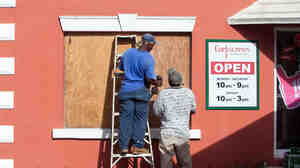 Workers board up a restaurant Thursday in Flatts Village as Bermudans prepare for the arrival of Hurricane Gonzalo. The storm will hit the island Friday.
