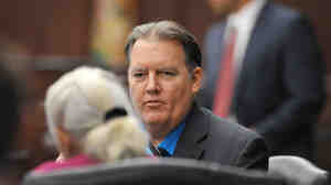 Michael Dunn talks with a member of his defense team during the first break in his retrial at the Duval County Courthouse in Jacksonville, Fla., in September.