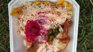 Pollo con tajadas is a traditional Honduran dish consisting of fried chicken with fried green plantains.