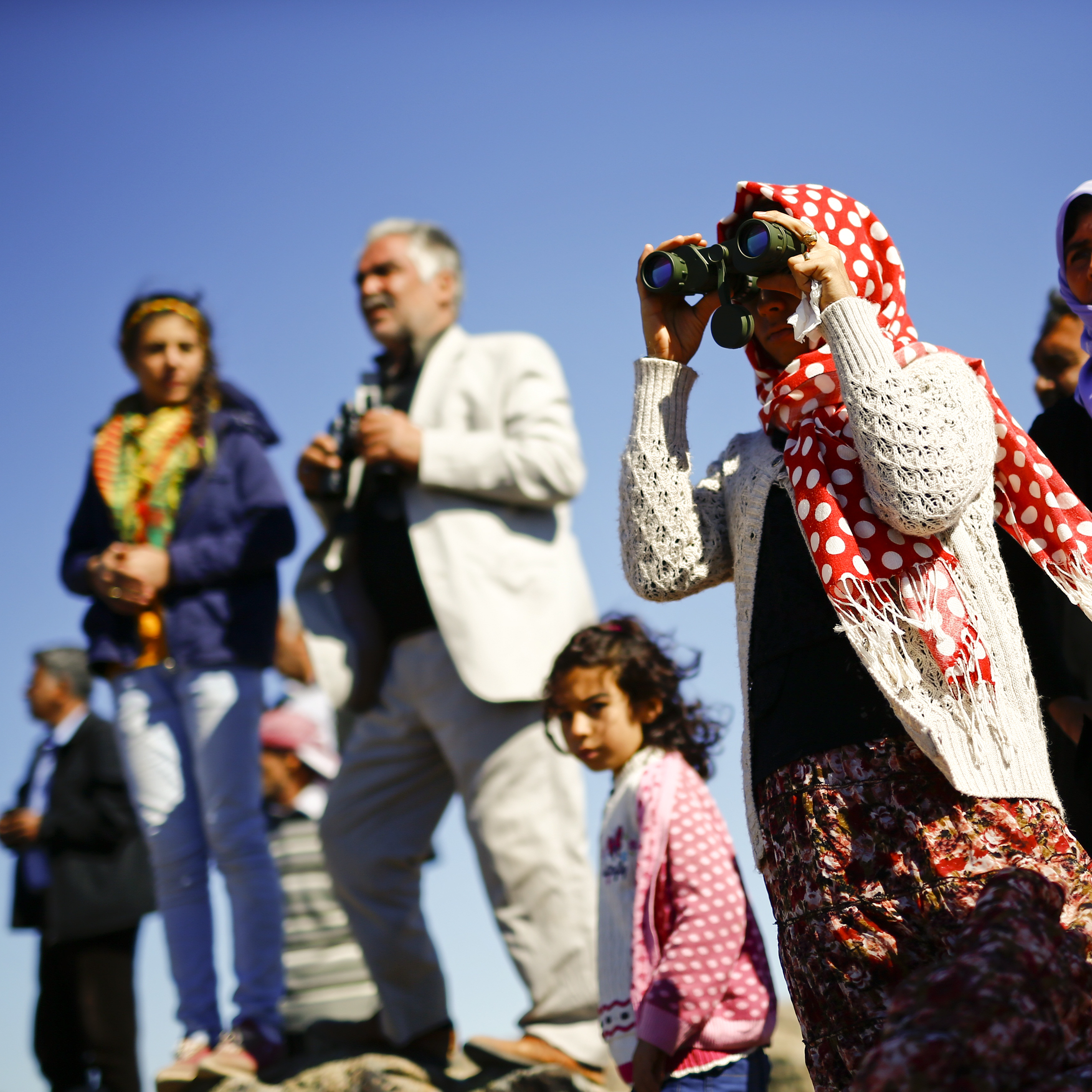 Turkish Kurds watch the Syrian town of Kobani from a hill near the Mursitpinar border crossing on Monday.