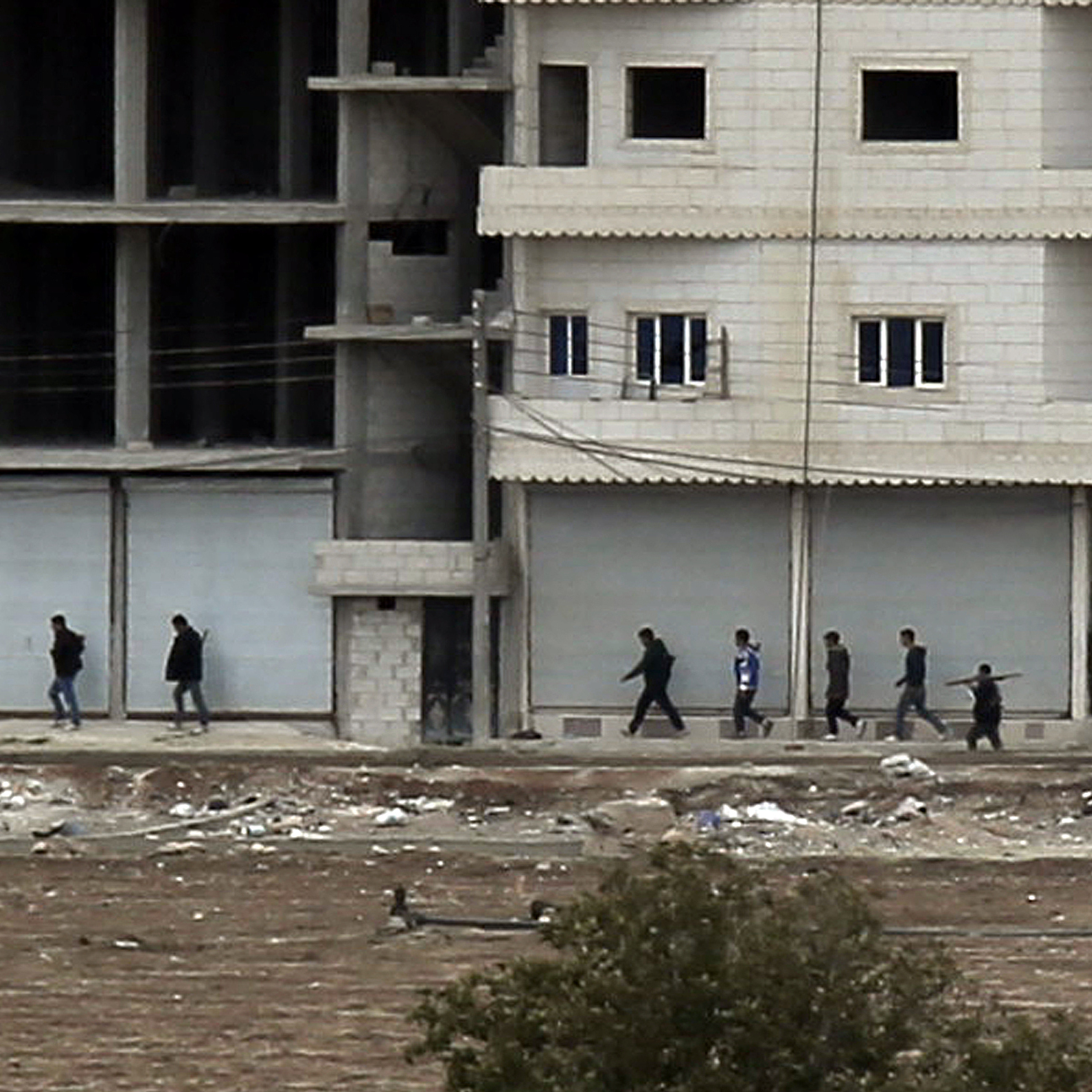 Kurdish fighters move into position in Kobani, Syria on the border with Turkey Sunday, Oct. 19, 2014.