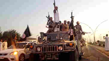 Militants from the Islamic State parade in a commandeered Iraqi security forces armored vehicle on a main street in Mosul, Iraq, in June.