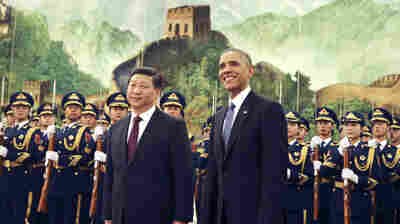 President Barack Obama, right, smiles after a group of children waved flags and flowers to cheer him during a welcome ceremony Wednesday with Chinese President Xi Jinping at the Great Hall of the People in Beijing.