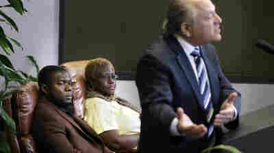 Josephus Weeks, left, nephew of Thomas Eric Duncan, and Mai Wureh, center, sister of Duncan, look on as attorney Les Weisbrod speaks during a news conference in Dallas on Wednesday.