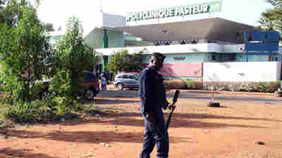 A police officer stands in front of the Pasteur clinic in Bamako, which was quarantined after a nurse there died from Ebola.