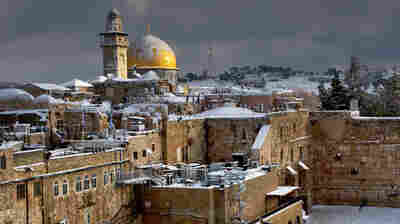 The gilded Dome of the Rock is part of the most important Muslim holy site in Jerusalem, while the Western Wall, in the midground on the right, is the holiest place for Jewish prayer. The photo was taken following a rare snowstorm in Jerusalem in December 2013.