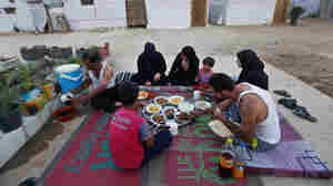 Syrian refugees break their fast outside their tent at a Syrian refugee camp in Marj, Lebanon, on June 29. The World Food Program says it has suspended a food voucher program serving more than 1.7 million Syrian refugees because of a funding crisis.