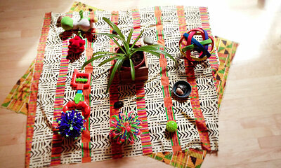Objects that represent concepts and ideas are placed on a mat in the middle of the circle. Objects that represent concepts and ideas are placed on a mat in the middle of the circle.