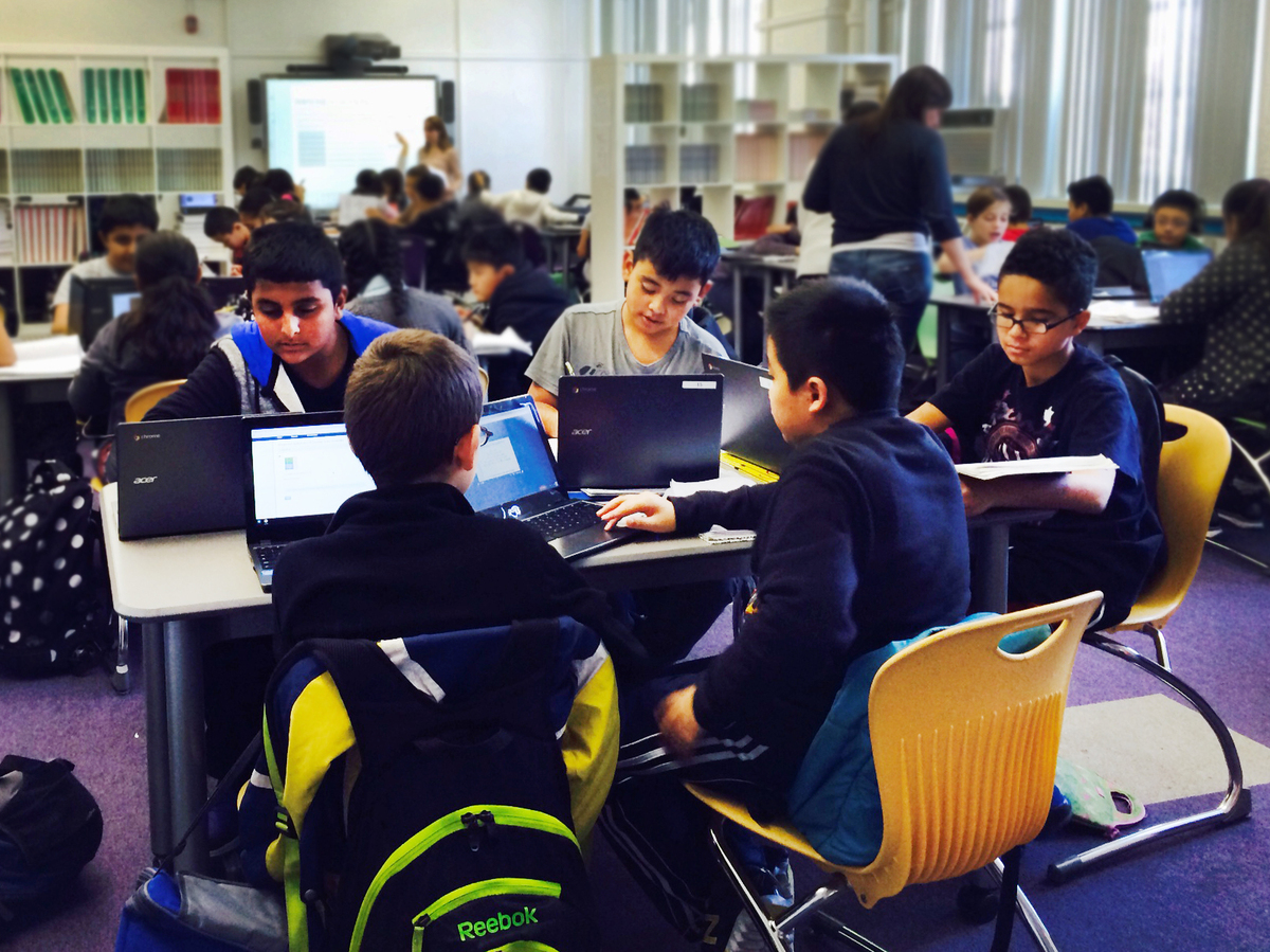 During a "virtual instruction" lesson, students work on their laptops.