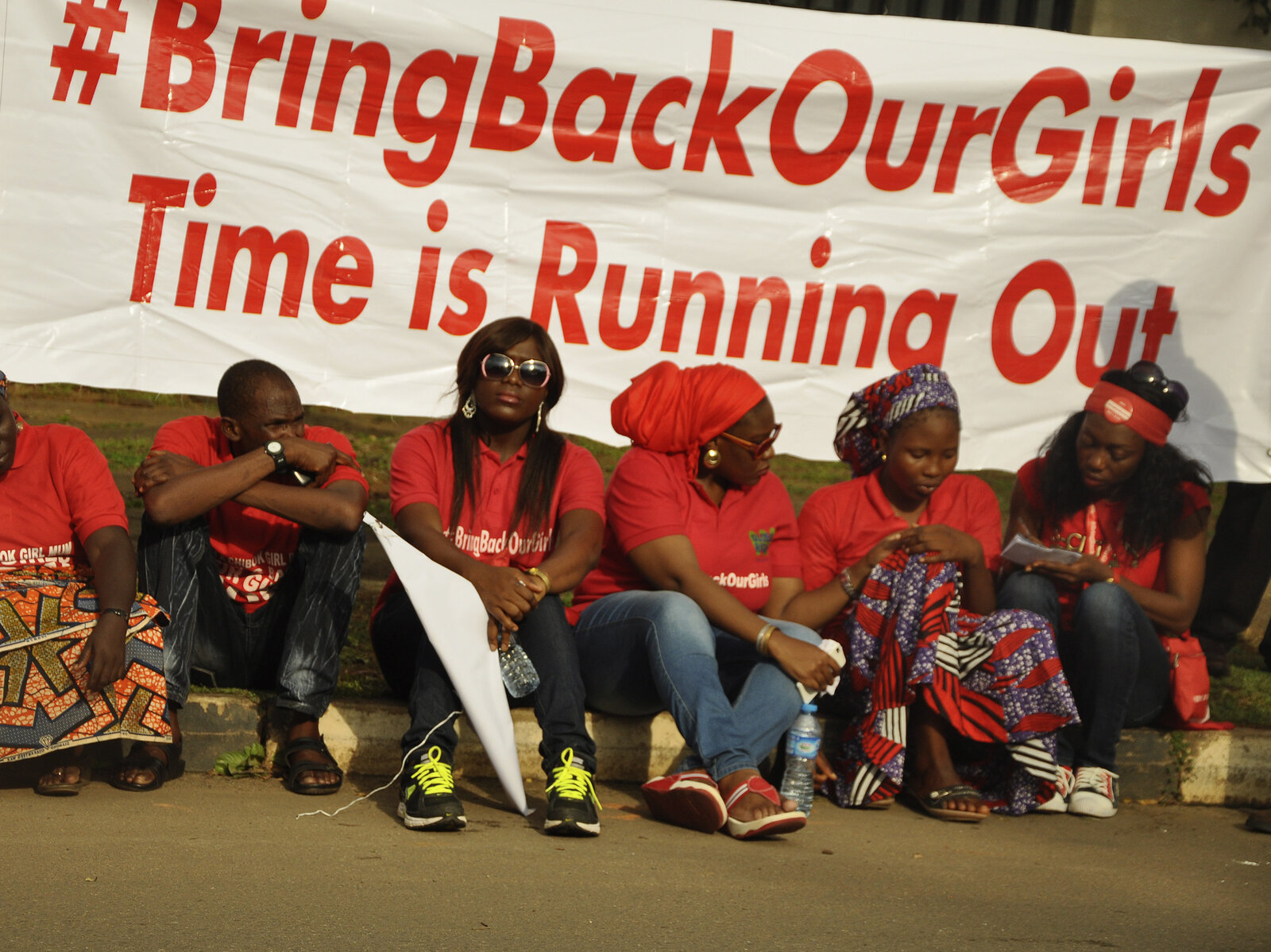 Members of the Abuja "Bring Back Our Girls" protest group sit during a march in continuation of the Global October movement. Once again, Boko Haram militants are implicated in killings and mass kidnapping in northeastern Nigeria.