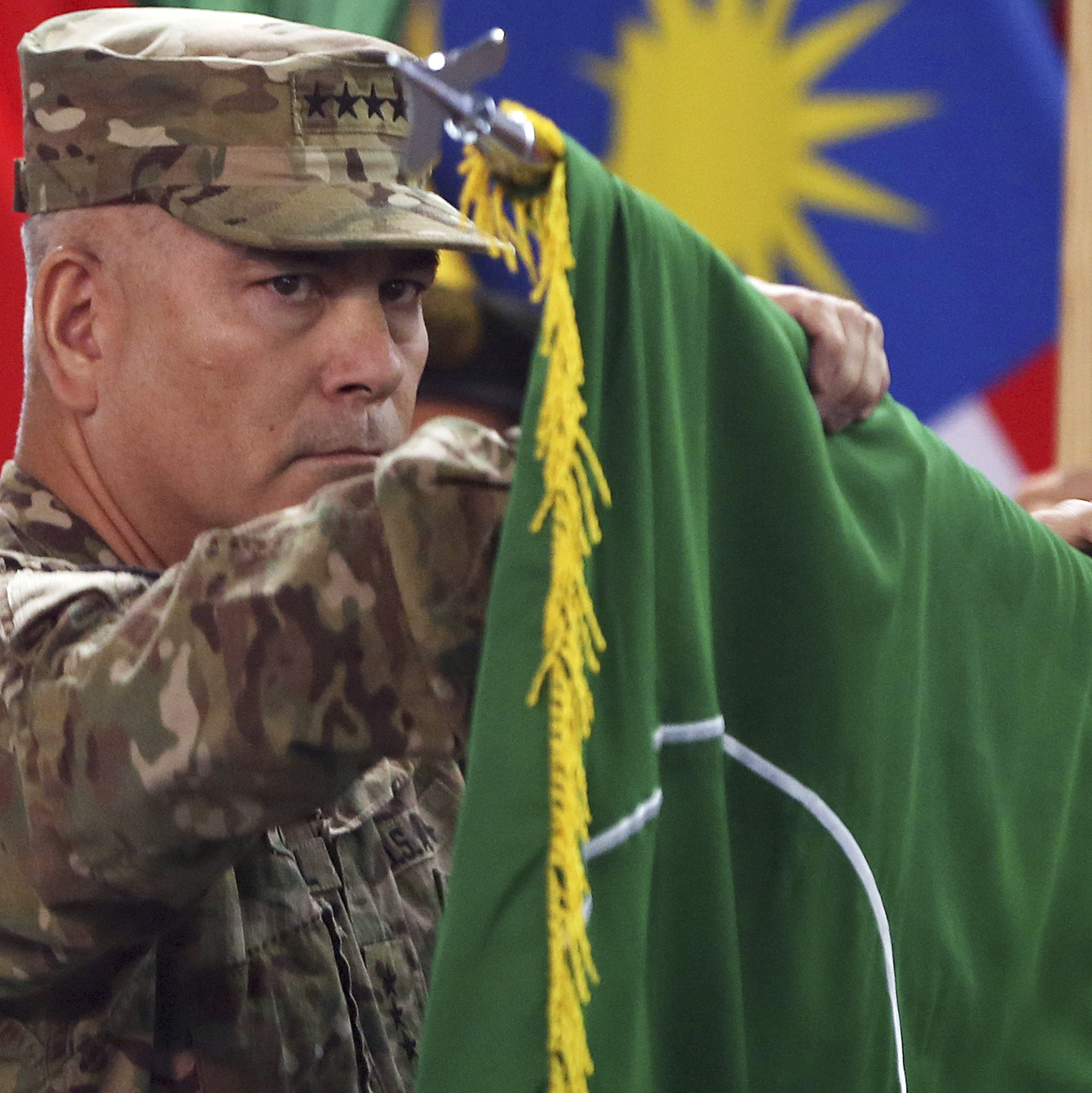 Commander of the International Security Assistance Force (ISAF), Gen. John Campbell opens the "Resolute Support" flag during a ceremony at the ISAF headquarters in Kabul on  Sunday.