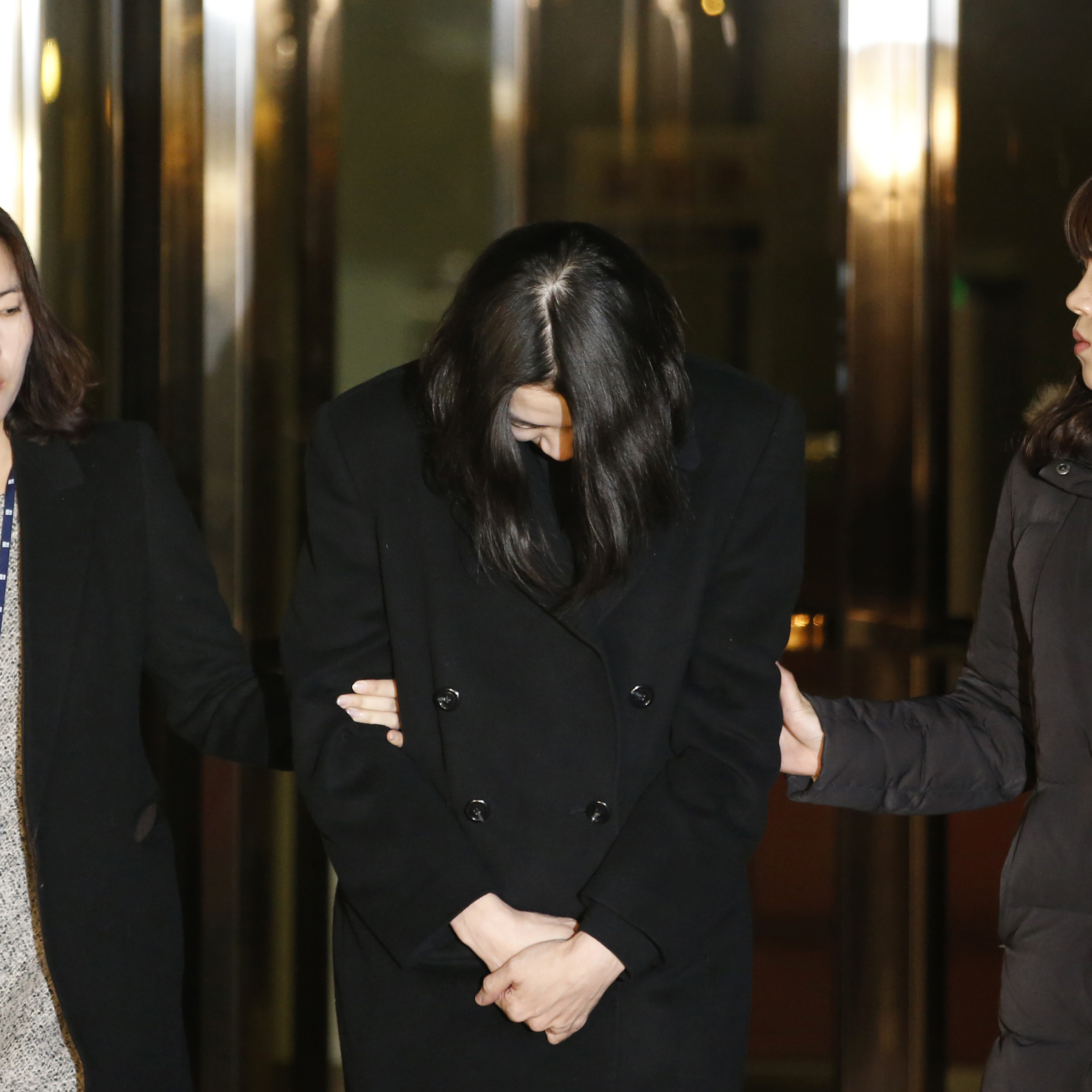 Cho Hyun-ah (center) leaves for a detention facility today following a court order. Cho served as head of in-flight service for Korean Airlines until earlier this month. Her conduct aboard an aircraft over a packet of improperly served macadamia nuts led to her resignation. She is accused of violating South Korea's aviation safety laws.