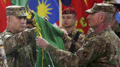 U.S. Gen. John Campbell (left) and Command Sgt. Maj. Delbert Byers open the Operation Resolute Support flag during a ceremony at the International Security Assistance Force headquarters in Kabul, Afghanistan on Sunday.
