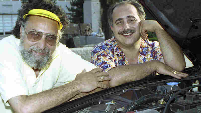 Brothers Tom (left) and Ray Magliozzi pose under a car hood in Boston. The comic duo hosted NPR's Car Talk for a quarter of a century before retiring in 2012. Since then, the show has been heard in reruns. Tom has died at age 77.