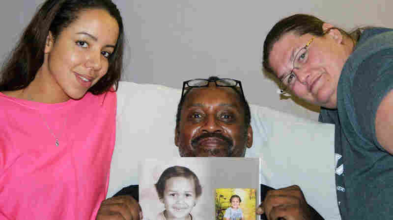 Megiddëh Goldston (left) with Heidi Hameed (right) and her husband, Raphael, at StoryCorps in Colorado Springs, Colo. Raphael holds photos of his son, Ish — short for Ishaq — who was killed in July when he was struck by a car driven by Megiddëh's sister.