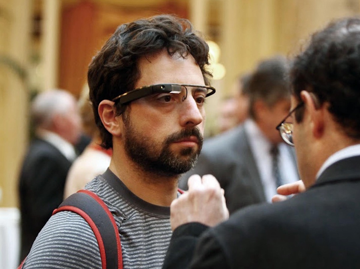 Google co-founder Sergey Brin wears Google's Project Glass prototype publicly for the first time while attending a charity function in San Francisco. Google is suspending public sales of its first generation of Google Glass next week.
