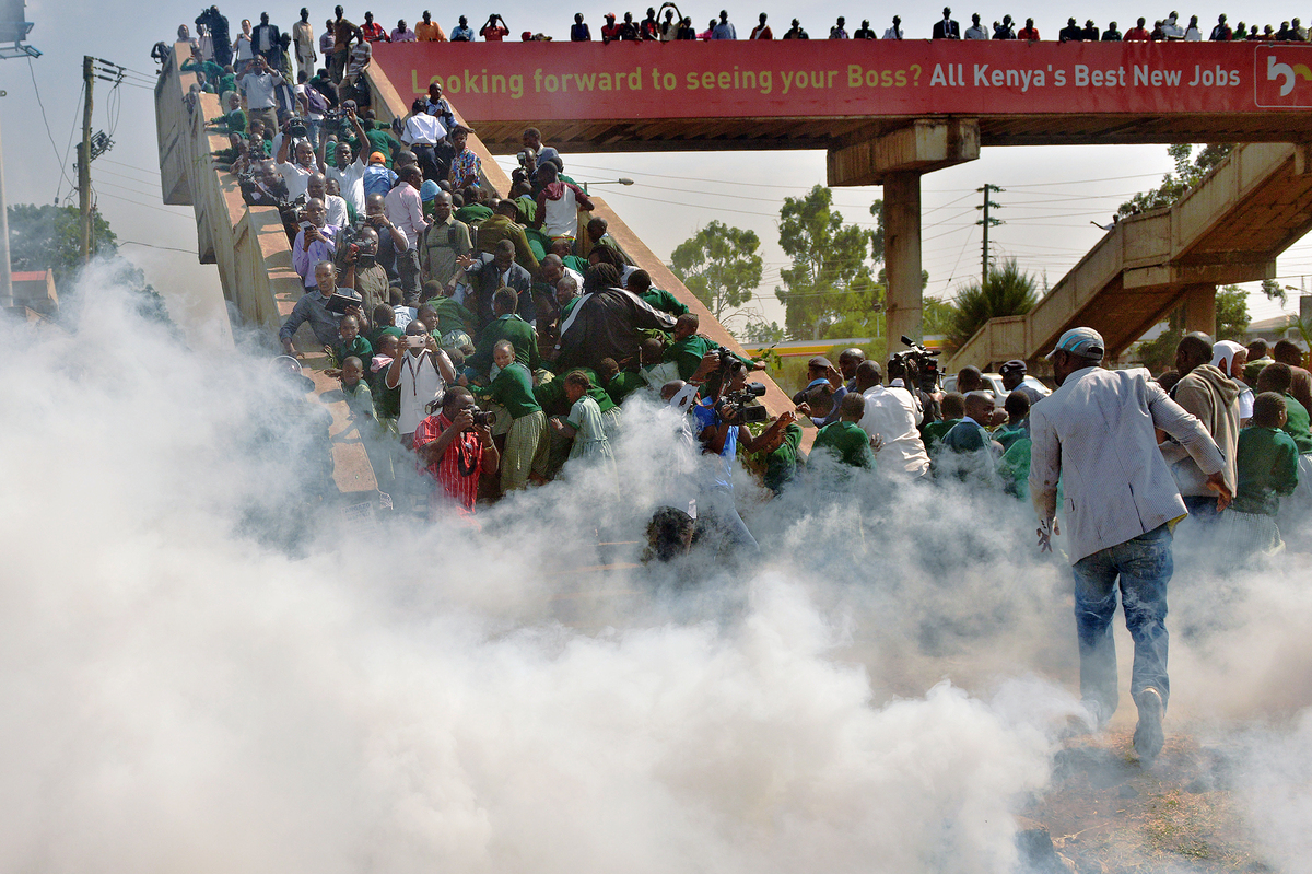 School children and activists scramble up a bridge Monday after police try to break up a protest with tear gas at the Langata Road Primary School in Nairobi, Kenya.