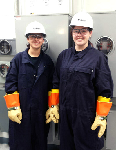 Haley Hughes (right) and Kristen Sabino stand in the meter training room at an NStar learning facility. The two are part of an apprenticeship program with the utility company, something economists say the U.S. needs more of in order to fill open trade jobs.