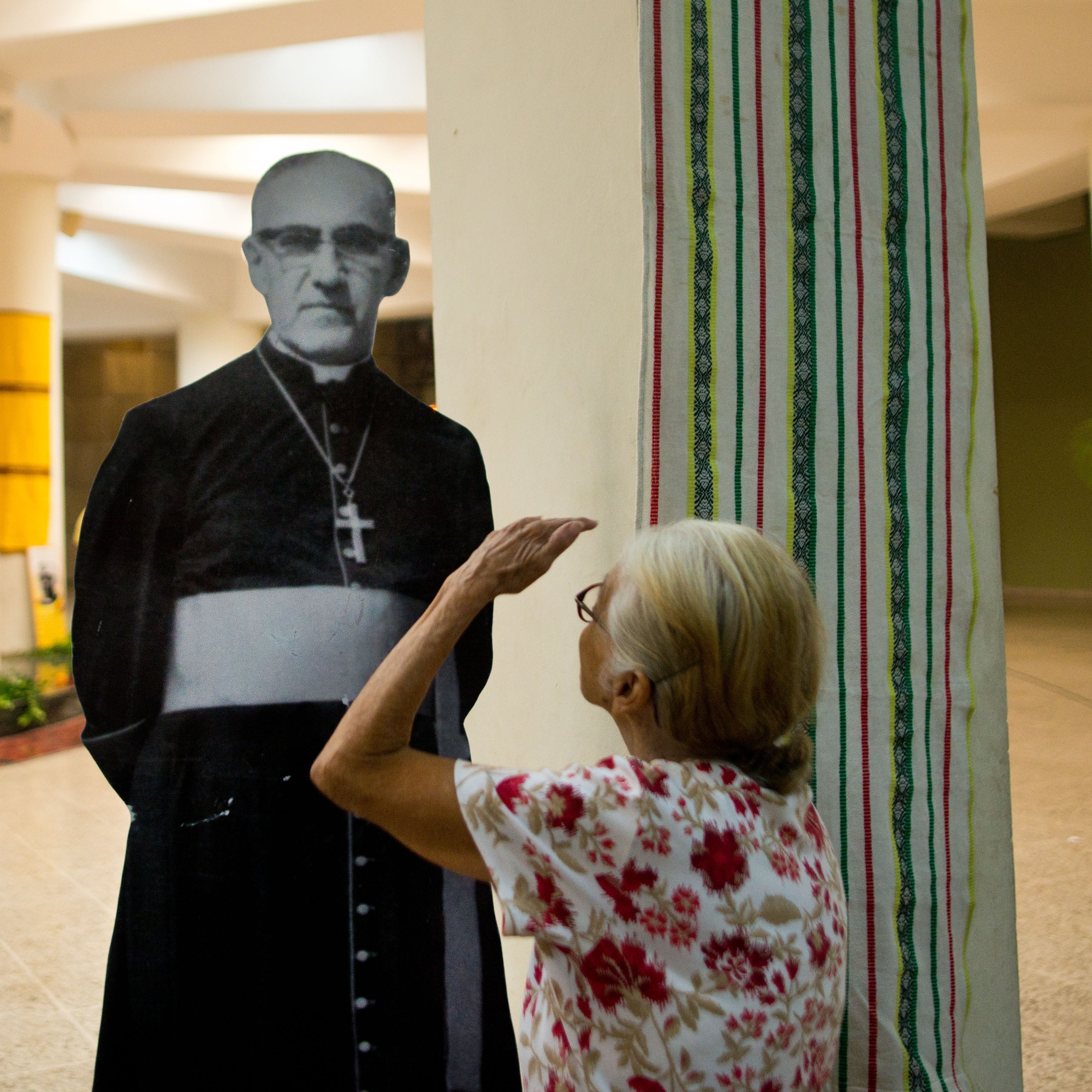 A Catholic faithful looks at a portrait of Monsignor Oscar Arnulfo Romero at his grave in the cathedral of San Salvador on March 24, 2014, during the commemoration of the 34th anniversary of his murder.