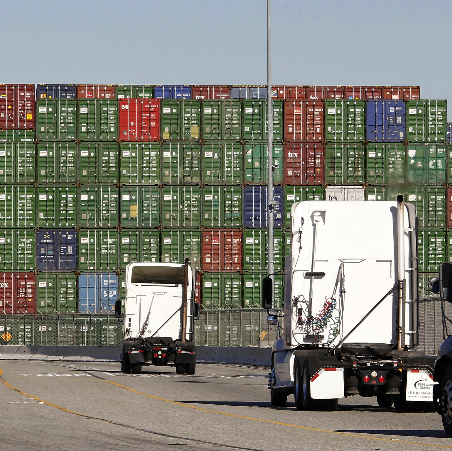 A few trucks move along the docks at the Port of Los Angeles on Thursday. Seaports in major West Coast cities that normally are abuzz with the sound of commerce are falling unusually quiet due to an ongoing labor dispute.
