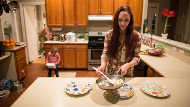 Maggie Barcellano prepares dinner in January 2014 at her father's house in Austin, Texas. Barcellano, who lives with her father, enrolled in the food stamps program while she works as a home health aide and raises her 3-year-old daughter. A study suggests that social safety nets, including food stamps, helped cushion income losses for middle- and working-class Americans during the recession. (AP)