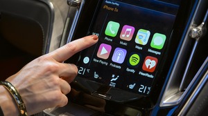 A visitor presses Apple's CarPlay touch-screen commands during the press day of the Geneva Motor Show in Geneva last March. Rumors this week suggested that Apple wants to move on to building its electric car, a historically perilous venture.