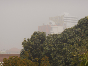 The view from the house where the author stays in Accra, Ghana. The buildings in the background are typically bright green and red, but a blanket of Harmattan haze has dulled their colors.