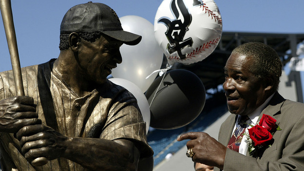 Minnie Miñoso smiles in front of a sculpture of him before throwing out the ceremonial first pitch at U.S. Cellular Field. Major League Baseball's first black Latino star, Miñoso died March 1, 2015. (AP)