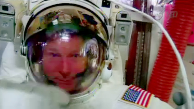 Astronaut Terry Virts points to his helmet as he sits inside the International Space Station on Wednesday. (AP)