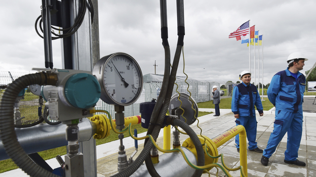 Workers stand next to a gas pipeline not far from the central Ukrainian city of Poltava in June 2014. Ukraine imports much of its gas from Russia, which is once again threatening to cut off supplies in a dispute over payments. (AFP/Getty Images)