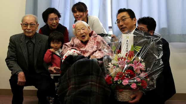 Misao Okawa, the world's oldest living person, poses for a photo with her son Hiroshi Okawa, 92, left, and other family members and friends on her 117th birthday celebration at Kurenai Nursing Home in Osaka, Japan. (Getty Images)