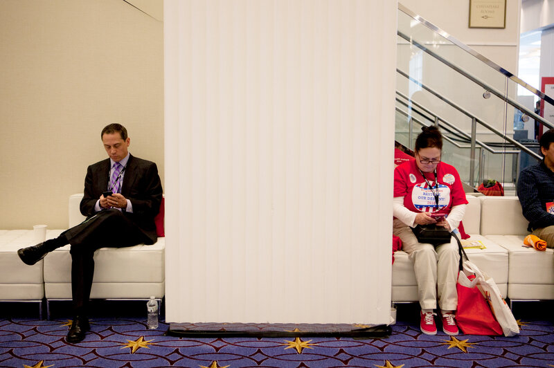 CPAC 2015 attendees take a break to check their phones.