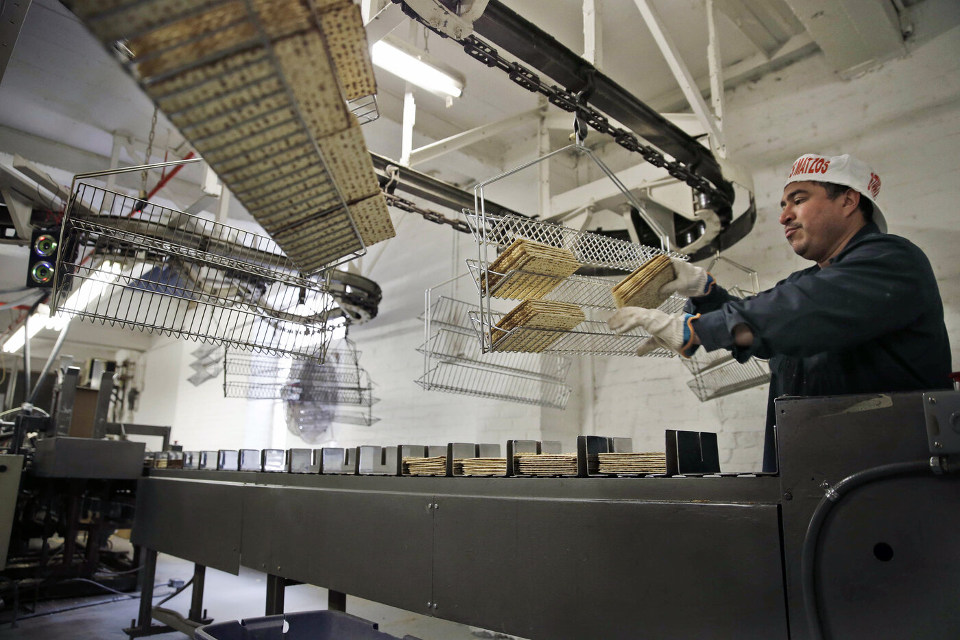 Edwin Caballeros loads fresh-baked matzos into a packaging machine at the Streit's factory in New York on March 4. Edwin Caballeros loads fresh-baked matzos into a packaging machine at the Streit's factory in New York on March 4.