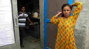 Saroj's teenage son watches her comb her hair before she heads to work.