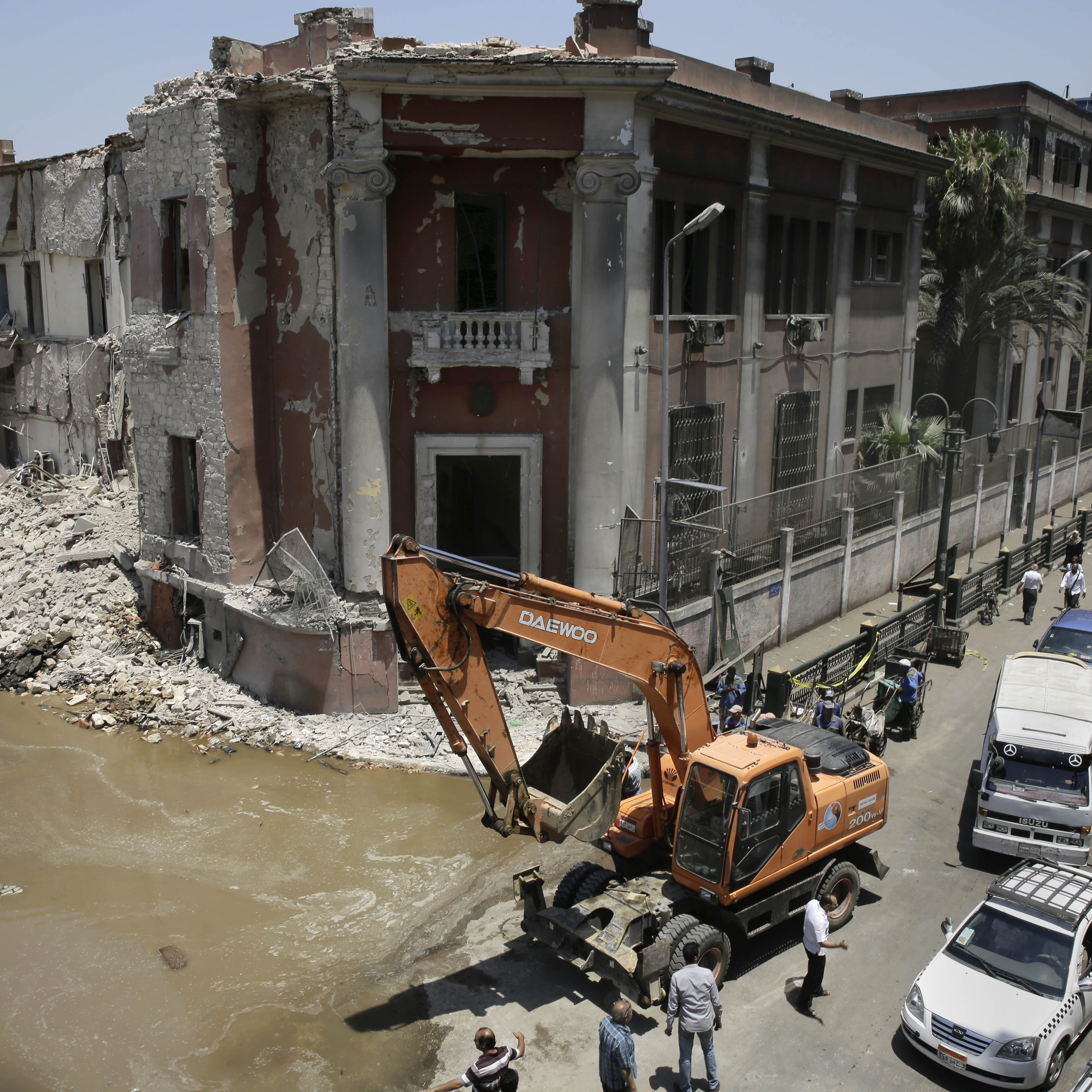 Workers clear rubble at the site of a car bomb explosion near the Italian Consulate in downtown, Cairo, Egypt, on Saturday.
