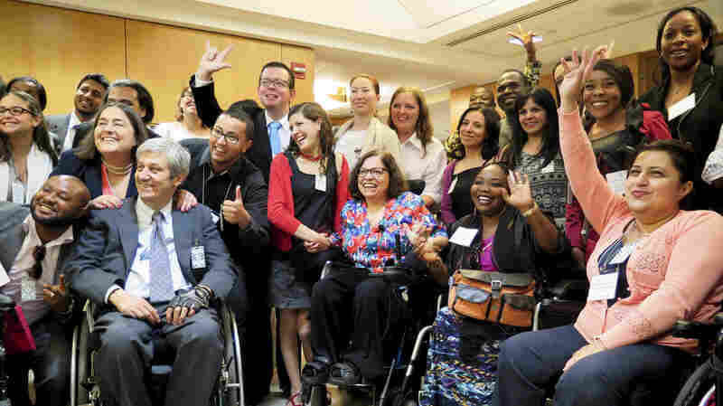 At the State Department conference for people with disabilities, adviser Judy Heumann (center) is surrounded by admirers from around the world.