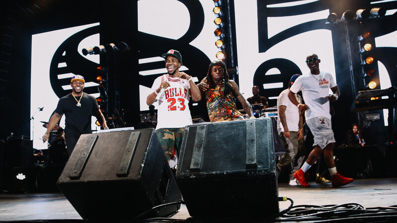 Lil Wayne dancing behind fellow New Orleans rapper Curren$y (in Bulls jersey).