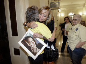 Debbie Ziegler holds a photo of her daughter, Brittany Maynard, as hugs supporter Ellen Pontac after a right-to-die measure was approved by the state Assembly on Wednesday in Sacramento, Calif.