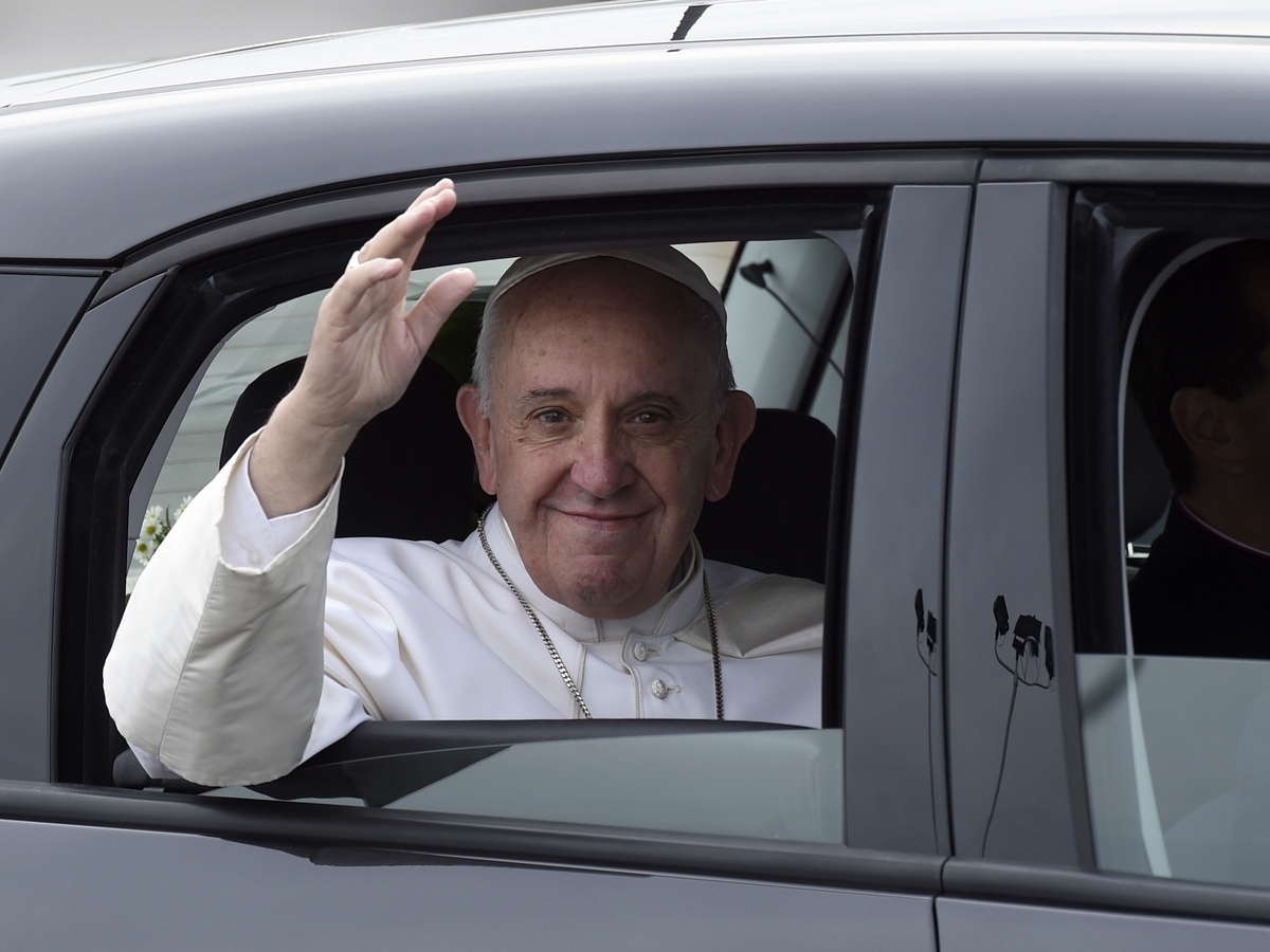 Pope Francis waves from inside his car after arriving at Philadelphia International Airport on Sept. 26.