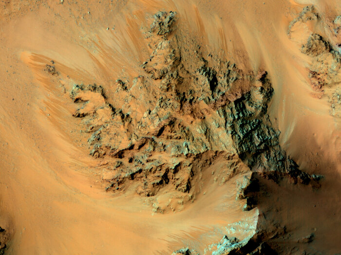 For several years, a satellite orbiting Mars has seen streaks flowing from Martian mountains during warm periods on the surface. Scientists have now confirmed that water is involved. (NASA/JPL/University of Arizona)