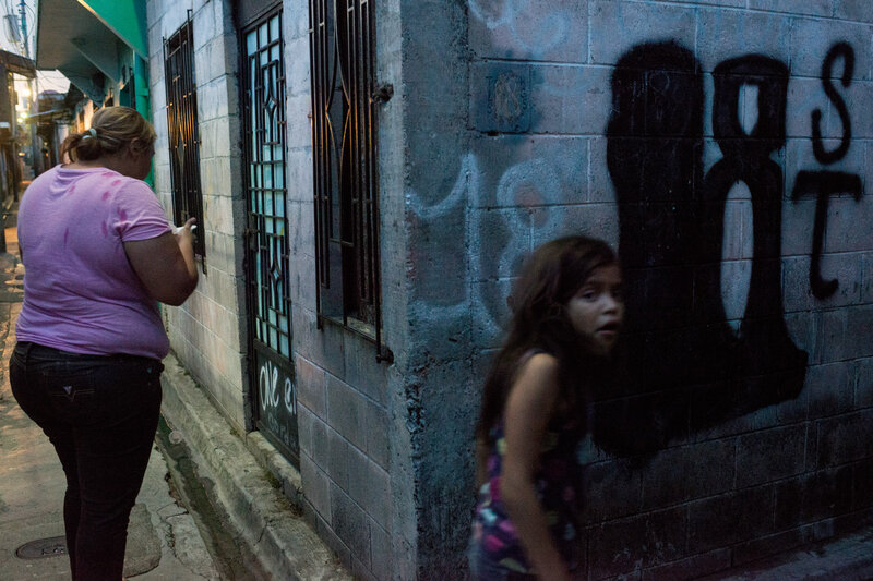 Mother and daughter hang around the streets of a residential area in San Salvador controlled by the gang Barrio 18. (Encarni Pindado/for NPR) Mother and daughter hang around the streets of a residential area in San Salvador controlled by the gang Barrio 18.
