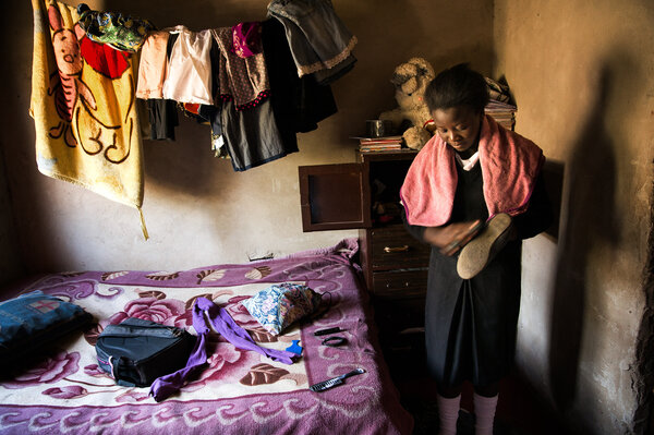 Madalitso Mulando brushes off her shoes before heading to school in Lusaka, Zambia. Last year, she missed a whole semester while her parents struggled to scrape together tuition. (Samantha Reinders for NPR)