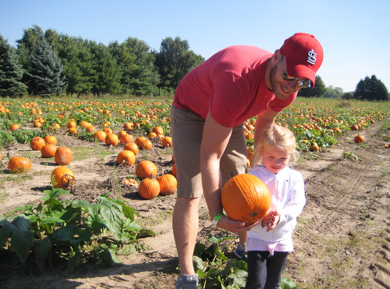 Kevin Coppinger took his nearly 3-year-old daughter, Mae, to choose a pumpkin at Waldoch Farm. The farm added a corn maze about five years ago. Owner Doug Joyer says adding such attractions has allowed him to live solely off income from the farm. (Kaomi Goetz/NPR)