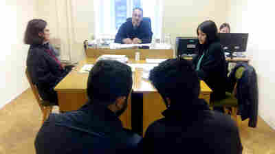 Mustafa Abdul Saleh, at right front, a 20-year-old Kurd from Syria, confers with a Kurdish interpreter, at left, during his trial in Szeged, Hungary. Saleh passed through a hole in the razor wire fence that Hungary has built on its border with Serbia. Breaching the fence is a criminal offense, and Saleh was expelled from Hungary and ordered back into Serbia.