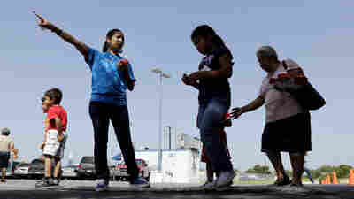 A volunteer with the Koch-funded Libre Initiative directs people in 2014 as groceries are distributed at a food bank it partially sponsors in San Antonio, Texas.