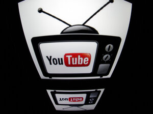 YouTube logo is seen on a tablet screen. YouTube logo is seen on a tablet screen.