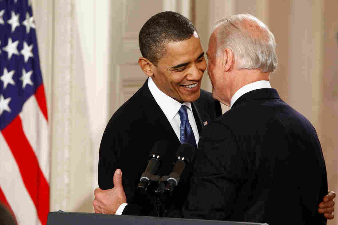Biden leans in to congratulate President Obama on signing the Affordable Care Act into law during a ceremony in the East Room of the White House on March 23, 2010.