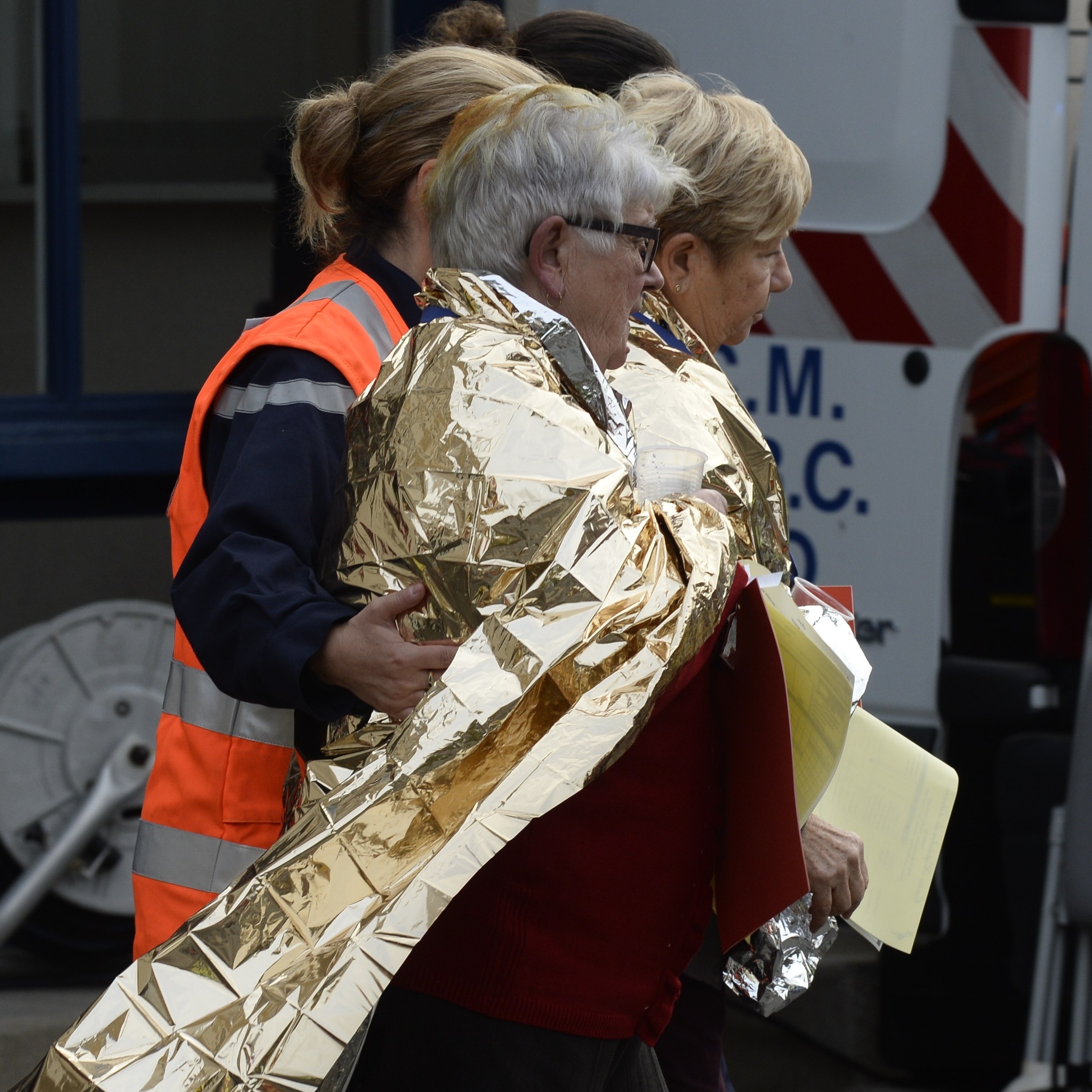 Emergency personnel escort people away from the site of a collision in Puisseguin in southwestern France. At least 40 people, most of them elderly, were killed when a bus collided with a truck  and caught fire in southwest France.